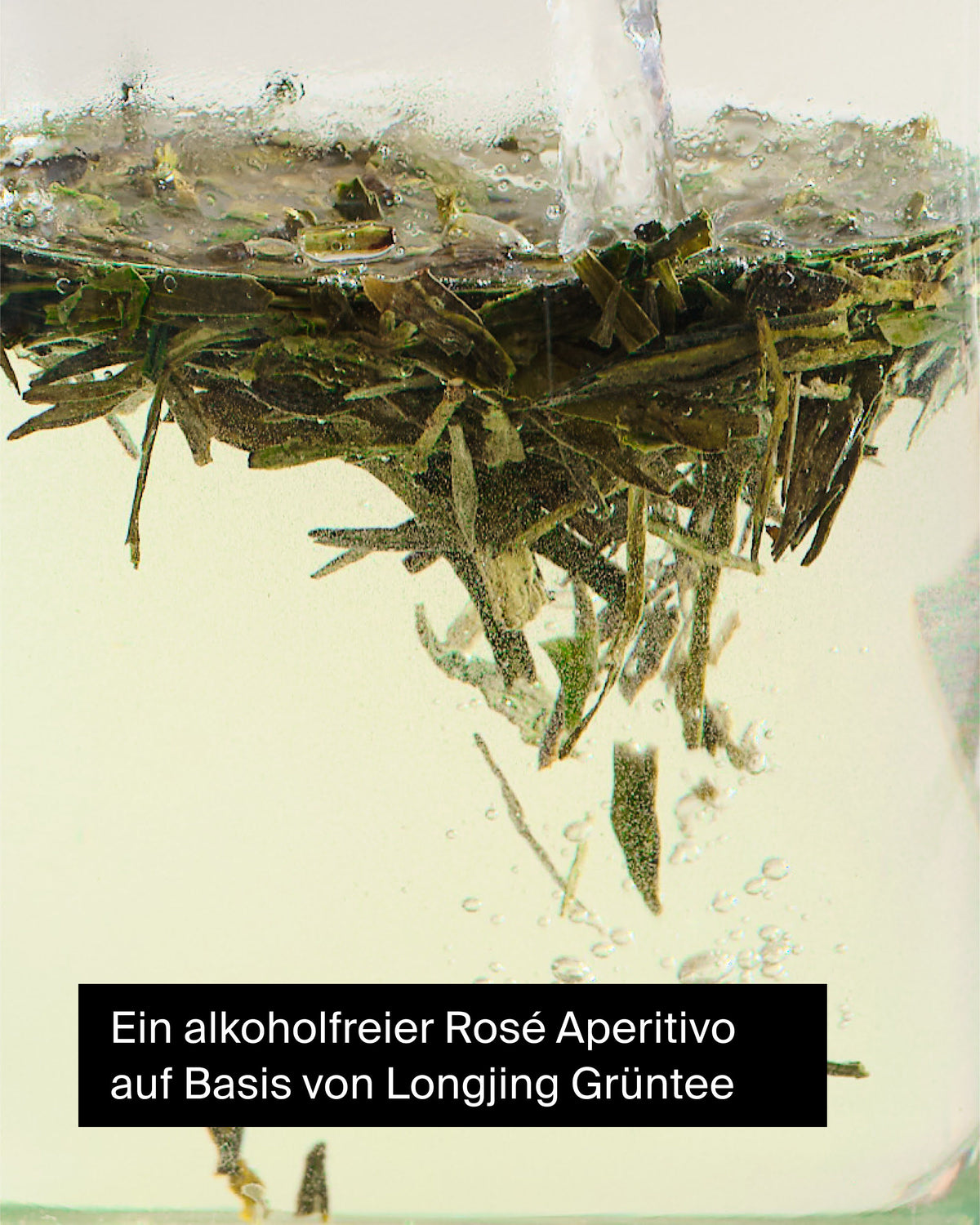 Nahaufnahme von Longjing-Grünteeblättern, die in klarem Wasser ziehen, mit Text über alkoholfreien Rosé Aperitivo.