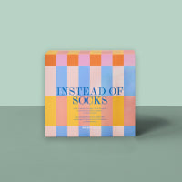 Quadratische Geschenkbox mit pastellfarbenem Karomuster in Rosa, Orange, Blau und Weiß.