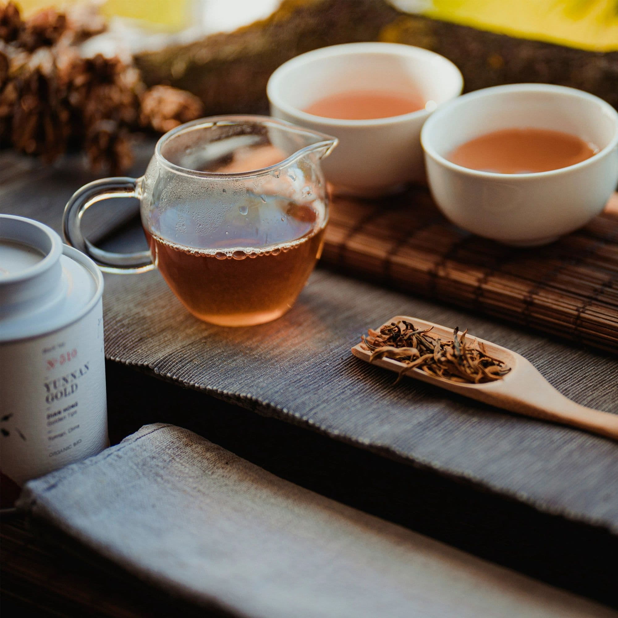 Glaskanne mit bernsteinfarbenem Dian Hong Tee, zwei Tassen, lose Teeblätter, BIO-Teedose aus Yunnan