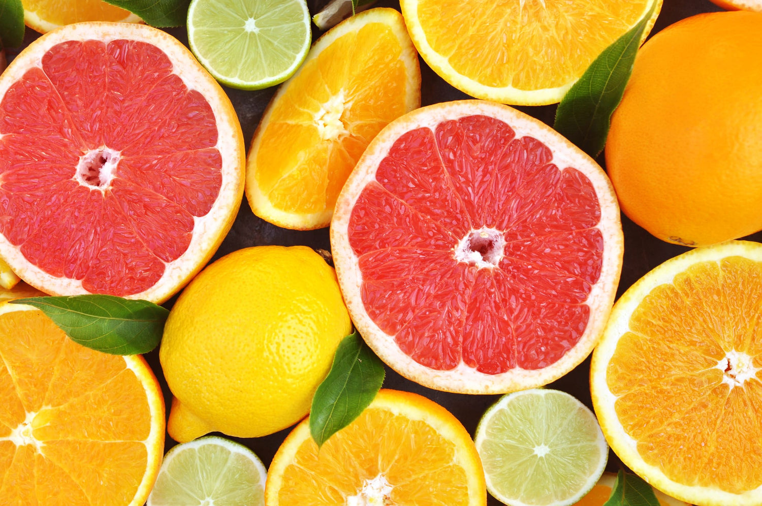 Rote Grapefruit-Hälften, Orangenscheiben, Zitronen und Limetten