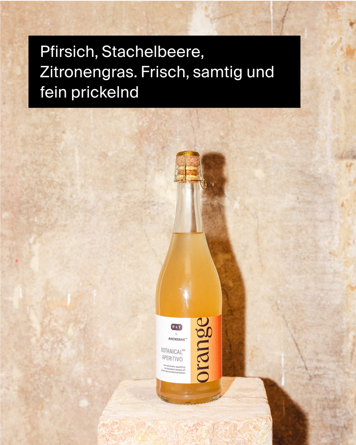 Klare Glasflasche mit hellem Orangen-Aperitif auf beigem Steinsockel, beschriftet mit P&T.
