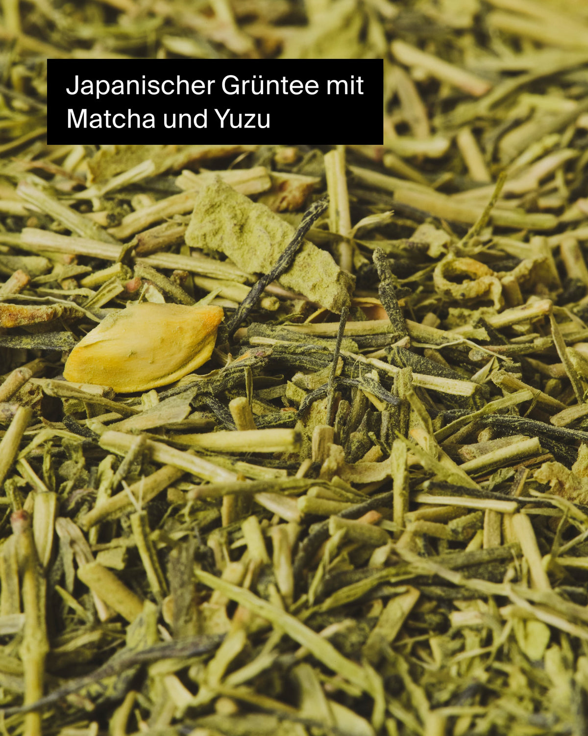 Nahaufnahme von japanischem Grüntee mit Matcha-Pulver und Yuzu-Stückchen, in grünen und gelben Tönen.