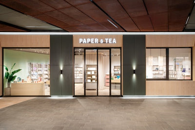 Moderne Ladenfassade mit Glasfront und beleuchtetem P&T-Schriftzug über dem Eingang.